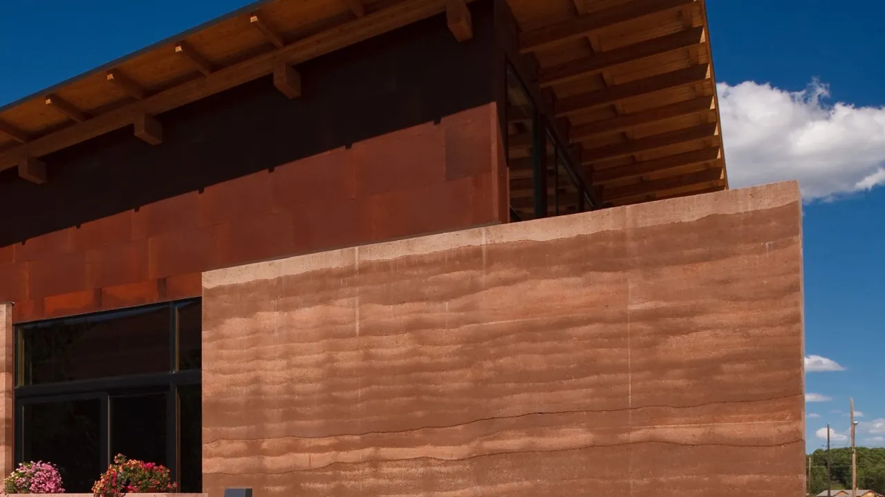 Rammed earth wall layers compacted in formwork (commissioned illustration, non-stock; no AD Studio 9 rammed earth project implied)